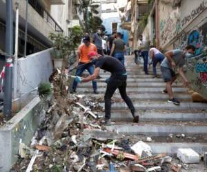 Personas remueven escombros de una calle tras la explosión en Beirut, Líbano. Foto AP.