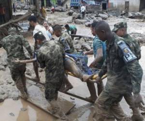 Soldados cargan cuerpos de los fallecidos en fenómeno natural en Colombia. Fotos: AFP