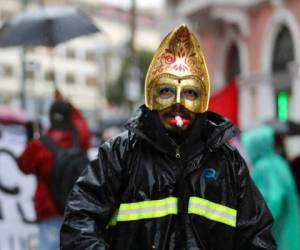 Un manifestante con una máscara de carnaval marcha durante una protesta para rechazar las políticas económicas del gobierno, el aumento del desempleo y la firma de un acuerdo con el Fondo Monetario Internacional, en Quito, Ecuador. Foto AP.