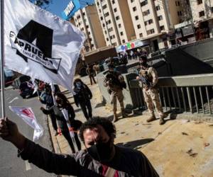 Un hombre ondea una bandera de campaña a favor de la reforma de la constitución nacional antes de un referéndum sobre el tema en Santiago, Chile. Foto AP.