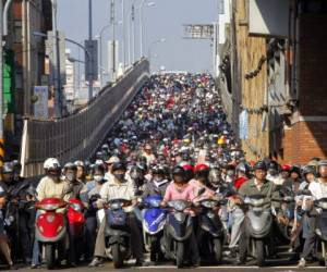 Miles de personas hacen largas filas en sus motocicletas para llegar a sus trabajos.