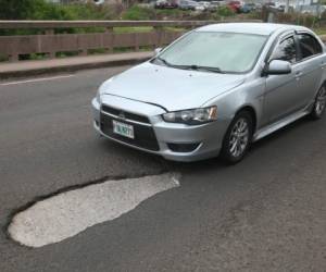 A inmediaciones del desvío a Valle de Ángeles, en el anillo periférico, un enorme bache amenaza la vida de decenas de conductores que a diario circulan por ese sector. Foto: Efraín Salgado/EL HERALDO.