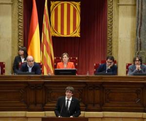 Catalan regional government president Carles Puigdemont (C) gives a speech at the Catalan regional parliament in Barcelona on October 10, 2017.Spain's worst political crisis in a generation will come to a head as Catalonia's leader could declare independence from Madrid in a move likely to send shockwaves through Europe. / AFP PHOTO / LLUIS GENE