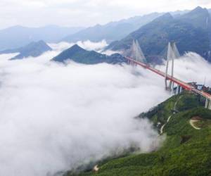﻿Un puente que se eleva más de 500 metros por encima del curso de un río, y presentado como 'el más alto del mundo' fue abierto este jueves a la circulación en China, donde une dos provincias de montaña del suroeste del país, foto: AFP.