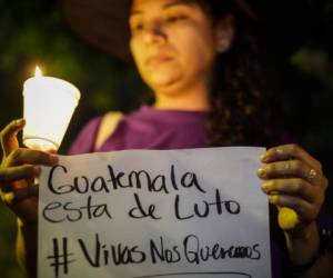 Guatemala está de luto: Viva nos quemaron, se lee en la pancarta que detiene con sus manos esta mujer.