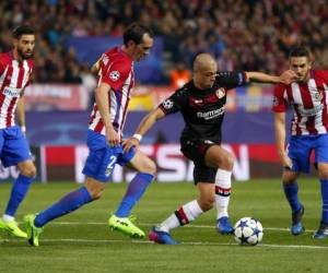 El mexicano Javier Hernández controla el balón ante la marca de los jugadores del Atlético de Madrid (Foto: Agencia AFP)