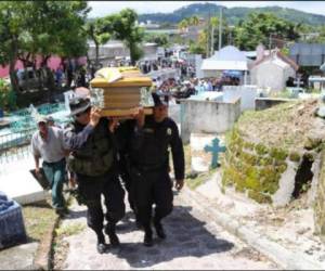 Elementos de la Policía Civil de El Salvador cargan a uno de sus compañeros asesinado por pandilleros.
