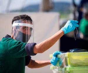 AG22429 - Santoña, España: un pescador que usa equipo de protección, sostiene algunas anchoas después de descargar la captura del día, en el puerto de la ciudad española de Santona, el 20 de abril de 2020 durante un cierre nacional para prevenir la propagación de la enfermedad COVID-19 . España dijo que 399 personas murieron de COVID-19 en las últimas 24 horas en lo que fue el número más bajo de muertes diarias en cuatro semanas, dijo el gobierno. / AFP / ANDER GILLENEA