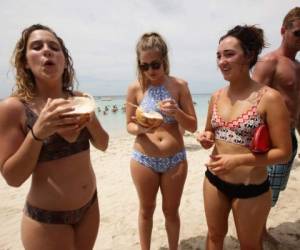 Estas tres hermosas extranjeras disfrutan de una deliciosa y refescante agua de coco. Foto: Emilio Flores/ EL HERALDO