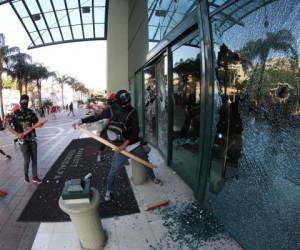 Momento en el que simpatizantes de la Alianza quiebran los vidrios de los ventanales del hotel Marriot durante una protesta el viernes en horas de tarde en la capital de Honduras.