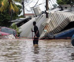 En esta foto de archivo del 6 de noviembre de 2020, un residente que camina por una calle inundada observa los daños causados ​​por el huracán Eta en Planeta, Honduras. Honduras lanzó un llamado de ayuda internacional para enfrentar los efectos devastadores del paso de dos huracanes por Centroamérica y advirtió que podrían provocar una nueva oleada migratoria hacia Estados Unidos. Foto: AP