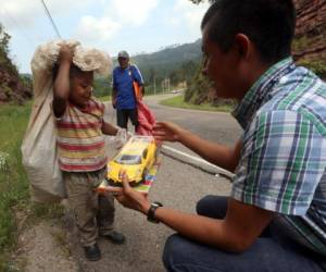 El pequeño Josué Zamora recibió un carro de juguete que dibujó una sonrisa en su rostro, al igual que en el de su padre. Foto: Johny Magallanes/El Heraldo.