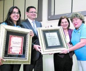 El ministro Marlon Escoto junto a Roxana Guevara entrega los reconocimientos póstumos a Hilda Caldera de Landaverde.