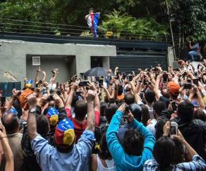 El opositor Leopoldo López saluda a sus seguidores desde el interior de su residencia (Foto: Agencia AFP)