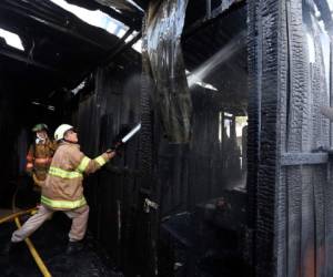 Bomberos trabajan en el enfriamiento de los puestos quemados.Foto: Marvin Salgado/EL HERALDO.