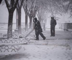 Los trabajadores limpian la nieve de las aceras adyacentes a la Casa Blanca en Washington. Foto: AFP