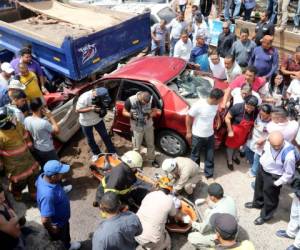 Elementos del Cuerpo de Bomberos extraen el cuerpo, aún con vida, del vehículo parcialmente destruido en el anillo periférico.