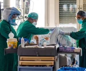 Medical workers tend to a patient at the Intensive Care Unit of the Tor Vergata Covid-4 hospital on April 21, 2020 in Rome, during the country's lockdown aimed at curbing the spread of the COVID-19 infection, caused by the novel coronavirus. (Photo by Andreas SOLARO / AFP)