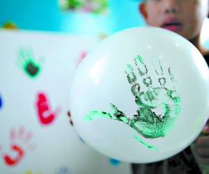JUEGOS. Los niños fueron recibidos ayer en espacios y áreas de entretenimiento. Este menor dibujó su mano en el globo.