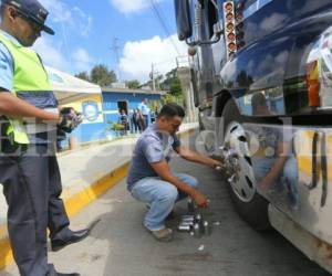 Los agentes detallaron que las unidades no pueden llevar en sus llantas tapas que terminan en punta o sobresalen demasiado, pues se torna muy peligroso para el camino en las carreteras de Honduras, foto: Johny Magallanes / EL HERALDO.