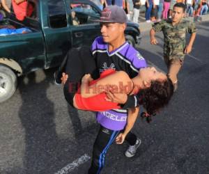 Una joven familiar de la víctima se desmaya y es cargada luego de conocer la tragedia ocurrida en El Carrizal. (Foto: Ronald Aceituno/ El Heraldo Honduras/ Noticias Honduras hoy)