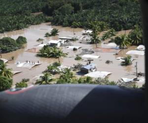 Esta foto del folleto de la Fuerza Aérea de los EE. UU. Publicada el 8 de noviembre de 2020 muestra a hondureños parados en los tejados rodeados por las inundaciones del huracán Eta en San Pedro Sula, Honduras, el 7 de noviembre de 2020.