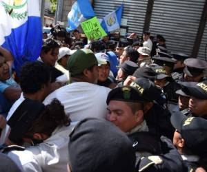 Honduran riot police members throw tear gas at students blocking the Comunidad Economica Europea boulevard to demand the resignation of President Juan Orlando Hernandez in Tegucigalpa, on June 25, 2019. - Ongoing protests against Hernandez intensified last week after beginning more than a month ago when doctors and teachers unions held strikes against health and education laws. (Photo by ORLANDO SIERRA / AFP)