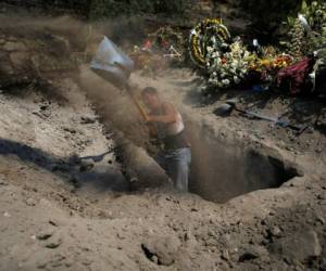 Un trabajador cava una tumba en el cementerio municipal de Valle de Chalco, en las afueras de la Ciudad de México, construido para dar cabida al creciente número de muertos por la pandemia de coronavirus, el jueves 21 de mayo de 2020. (AP Foto/Marco Ugarte)
