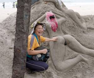 Una turista disfrutando de las esculturas de arena en Copacabana.