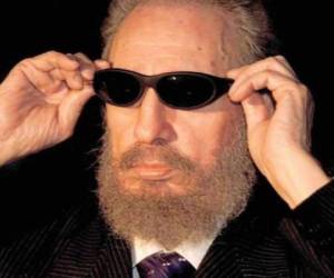 Fidel Castro se coloca unas gafas negras que le ofrecieron los componentes del programa de TV «Caiga Quien Caiga», al finalizar el almuerzo con los mandatarios asistentes a la IX Cumbre Iberoamericana, celebrado en el hotel Habana Club (1999).