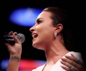 El cantante Demi Lovato realiza el himno nacional antes del combate estupendo del boxeo del welterweight entre Floyd Mayweather Jr. y Conor McGregor el agosto. Foto: Agencia AFP.