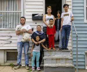 De izquierda a derecha Roberto (sosteniendo a Henry, el perro de la familia), su esposa Janeth y su hija Allison posan junto a la hermana de Janeth, Arley, y sus hijos Roberto, Dora y Sirus en la entrada de la vivienda de Arley en Baltimore. Foto: Agencia AP.