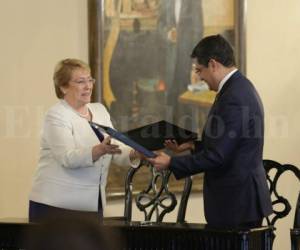 La presidenta chilena Michelle Bachelet y su homólogo hondureño, Juan Orlando Hernández, intercambian carpetas tras firmar una declaración conjunta sobre acuerdos comerciales y de cooperación en la Casa Presidencial en Tegucigalpa el 23 de agosto de 2017