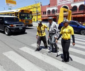 La presencia de agentes municipales auxiliares de tránsito se ha duplicado en la zona. Ahora los peatones pueden cruzar con mayor seguridad. Este adulto mayor recibió la asistencia de los agentes.Foto: Marvin Salgado/EL HERALDO