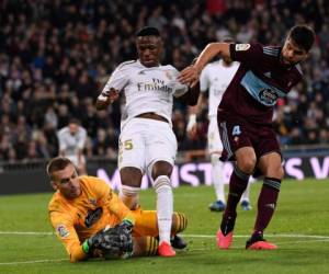 Madrid: el delantero brasileño del Real Madrid Vinicius Junior (C) desafía al portero español del Celta Vigo Rubén Blanco Veiga (abajo) durante el partido de fútbol de la liga española entre el Real Madrid CF y el RC Celta de Vigo en el estadio Santiago Bernabeu de Madrid el 16 de febrero de 2020. / AFP / PIERRE-PHILIPPE MARCOU