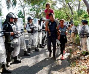 Ciudad Hidalgo, Chiapas, México: los inmigrantes centroamericanos, que se dirigen en una caravana a los EE. UU., Son bloqueados por miembros de la Guardia Nacional Mexicana en Ciudad Hidalgo, estado de Chiapas, México, el 23 de enero de 2020. Cientos de migrantes centroamericanos ingresaron a México El jueves, vadeando sin oposición a través de un río en la frontera guatemalteca donde las tropas mexicanas habían usado gases lacrimógenos a principios de la semana para retenerlos, informaron periodistas de la AFP en el lugar. / AFP / ALFREDO ESTRELLA