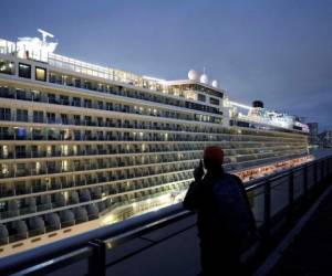 Una persona conversa por teléfono celular con un pariente a bordo del crucero “World Dream” atracado en la terminal de la empresa Kai Tak en Hong Kong, el sábado, 8 de febrero de 2020, debido a que no se permite el descenso de pasajeros ante la posibilidad de que algunos sean portadores del coronavirus. (AP Foto/Kin Cheung)