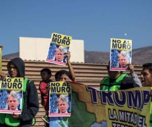 Miembros de las ONG Ángeles Sin Fronteras y Alianza Migrante, manifestaron en Tijuana contra el muro que se edifica en la zona. (Foto: AFP/ El Heraldo Honduras/ Noticias Honduras hoy)