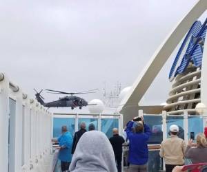 Fotografía proporcionada por Michele Smith de pasajeros observando cuando un helicóptero de la Guardia Nacional vuela sobre el crucero Grand Princess el jueves 5 de marzo de 2020 en la costa de California. (Michele Smith vía AP)