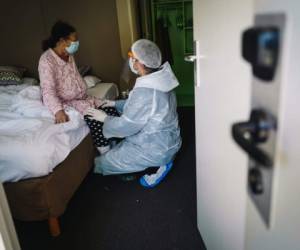El doctor Ozkaya (R) brinda atención a un paciente en un hotel convertido en un hospital improvisado para pacientes infectados con coronavirus, en Chelles, cerca de París, el 22 de abril de 2020, durante un El encierro en Francia tuvo como objetivo frenar la propagación de la pandemia de COVID-19. / AFP / LUCAS BARIOULET