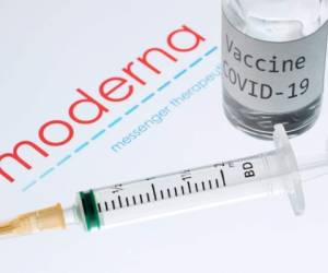 Esta foto de archivo tomada el 18 de noviembre de 2020 muestra una jeringa y una botella que dice 'Vaccine Covid-19' junto al logotipo de la empresa de biotecnología Moderna.