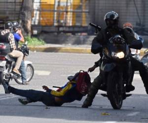 TOPSHOT - Members of the National Guard arrest an opposition activist during a demonstration against the government of Venezuelan President Nicolas Maduro, in Caracas on June 26, 2017.A political and economic crisis in the oil-producing country has spawned often violent demonstrations by protesters demanding Maduro's resignation and new elections. The unrest has left 75 people dead since April 1. / AFP PHOTO / Juan BARRETO