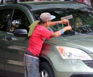 En su mayoría, los niños realizan labores como limpiar autos, donde apenas ganan unas monedas. Foto: EL HERALDO.