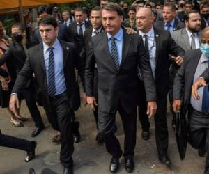 El presidente brasileño, Jair Bolsonaro (C), cruza la Avenida Paulista, hacia la Federación de Industrias del Estado de Sao Paulo (FIESP), en Sao Paulo, Brasil, el 25 de noviembre de 2020.