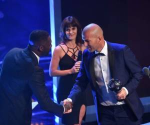 El actor británico Idris Elba (L) estrecha la mano del entrenador francés del Real Madrid Zinedine Zidane después de que Zidane gana el premio al mejor entrenador masculino de la FIFA de 2017 durante la ceremonia de los mejores premios de fútbol de la FIFA, el 23 de octubre de 2017 en Londres. / AFP / Ben STANSALL