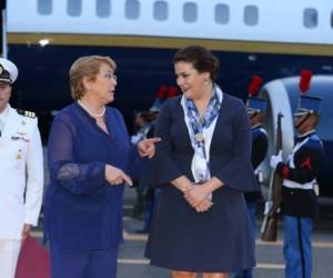 La presidenta de Chile, Michelle Bachelet, acompañada por la canciller de Honduras, María Dolores Agüero, tras desembarcar en la base aérea de Tegucigalpa.