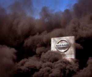 Se alza humo frente a la fábrica Nissan donde los trabajadores queman neumáticos en protesta en Barcelona, España, jueves 28 de mayo de 2020. La automotriz japonesa decidió cerrar sus plantas en la región de Cataluña, con la consiguiente pérdida de 3.000 empleos directos. (AP Foto/Emilio Morenatti)