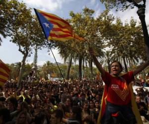 Una mujer gesticula y otros manifestantes ondean la 'estelada', la bandera independentista de Cataluña, durante una protesta en Barcelona, España, jueves 21 de septiembre de 2017. La Corte Nacional de España pondera posibles cargos de sedición contra manifestantes que participaron en una protesta masiva contra la operación policial contra los preparativos para un referéndum de independencia en Cataluña que Madrid ha dicho es ilegal, se anunció el miércoles, 27 de septiembre del 2017. (AP Foto/Emilio Morenatti)