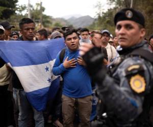 Migrantes hondureños que viajan en grupo se paran ante un policía guatemalteco, cerca de Agua Caliente, Guatemala, el 16 de enero de 2020, en la frontera con Honduras. (AP Foto/Santiago Billy)