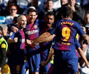 El delantero argentino del Barcelona Lionel Messi (2L) celebra con el mediocampista español Andrés Iniesta, el centrocampista brasileño Paulinho y el delantero uruguayo Luis Suárez después de marcar durante el partido de fútbol 'Clásico' de la Liga Española Real Madrid CF contra el FC Barcelona en el estadio Santiago Bernabéu en Madrid el 23 de diciembre de 2017. / AFP PHOTO / OSCAR DEL POZO